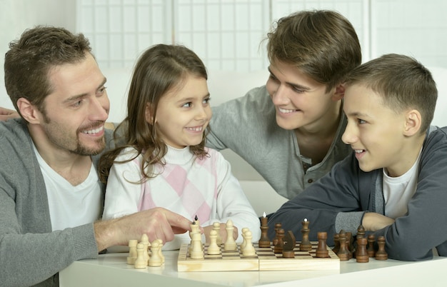 Family playing chess on a table at home