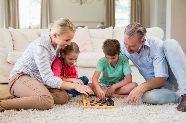 Family playing chess together at home in the living room