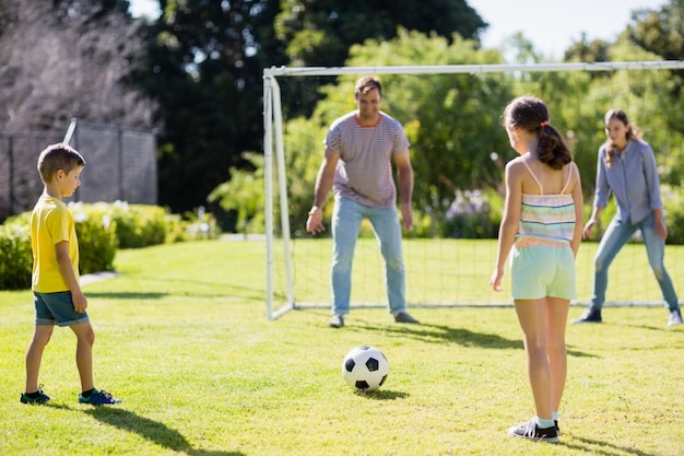 Famiglia che gioca a calcio insieme al parco