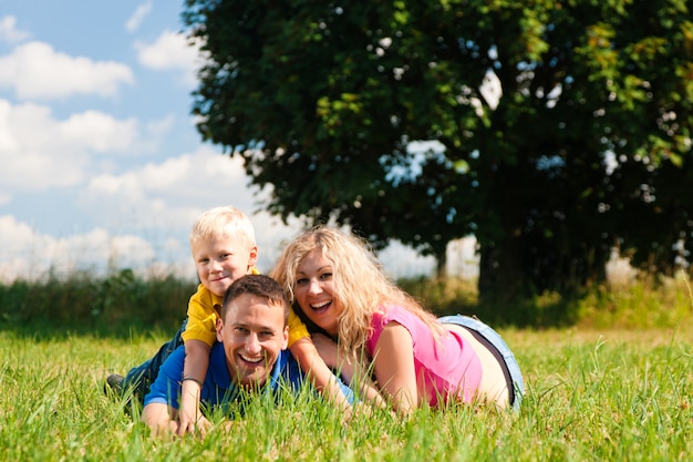 Family playing tag on meadow in summer