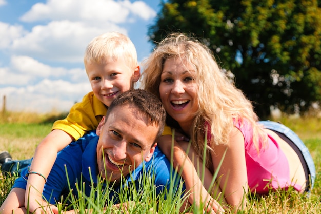 Family playing tag on meadow in summer