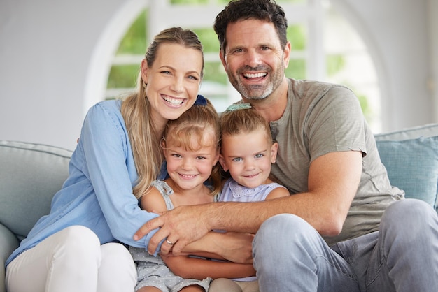 Family portrait man and woman with children bonding in house living room home interior and lounge sofa Happy smile love couple or mother and father with kids in trust security and support hug