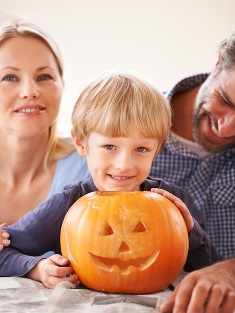 Photo family portrait and parents of kid with pumpkin to celebrate halloween fun and creativity at home happy boy child mom or dad carving face in orange vegetable holiday lantern and party decoration