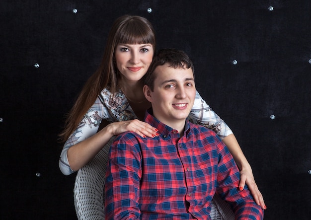 Family portrait of  young couple sitting on a chair