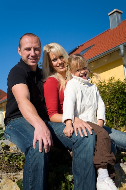 family posing in front of a house