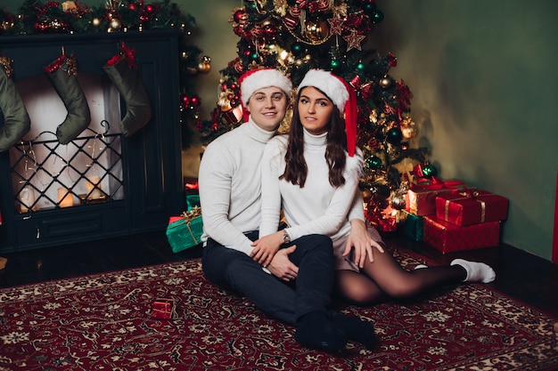 Famiglia in regali accanto all'albero di natale.