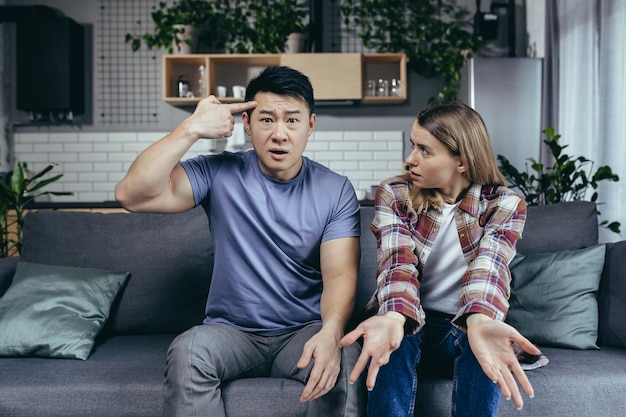 family quarrel woman complains about husband online consultation with a psychologist multiracial couple sitting on sofa at home