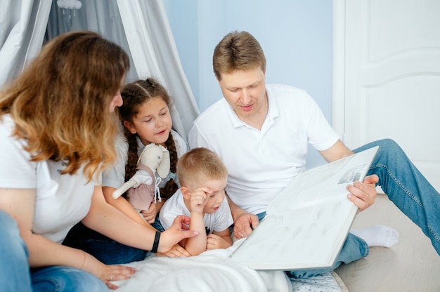 Famiglia che legge un libro mamma papà figlia e figlio