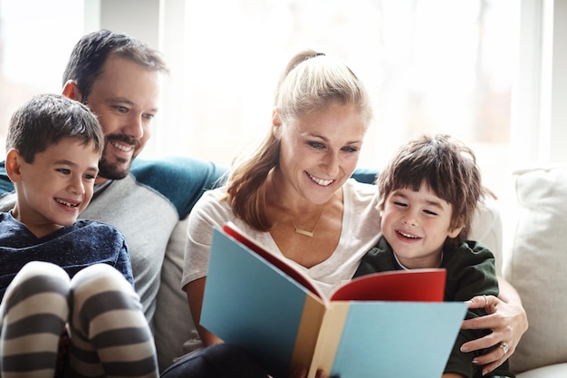 親子で一緒に本を読む家族、物語の時間と学習で家で幸せになる愛の関係と幸せな人々のリビングルームでの教育と子供たちとのお父さんとお母さんの絆