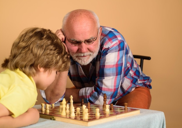 Family relationship with grandfather and grandson game of chess child playing chess with grandpa