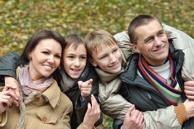 Foto famiglia che si rilassa in un bellissimo parco autunnale