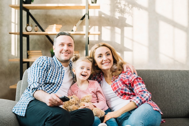 Photo family relaxing on sofa watching television at home