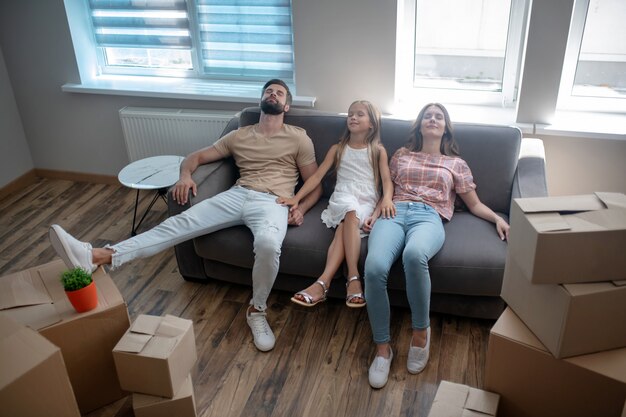 Family resting on the sofa after moving to a new house