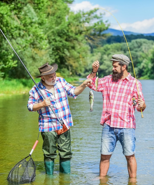 Family reunion time father and son fishing male friendship family bonding summer weekend two fishermen with fishing rods trout bait mature men fisher hobby and sport activity