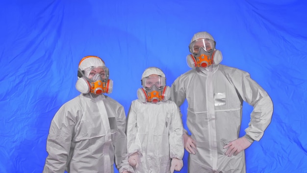 Family of scientists health worker in respirator mom dad and\
daughter wearing protect aerosol spray