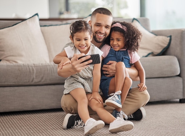 Family selfie and happy children sitting on lounge carpet at home with phone and taking photo or doing video call together Love bonding and care of single parent man with girl kids in brazil house