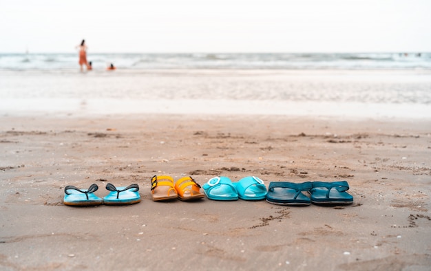 Family shoe slippers on the tropical beach in summer vacation