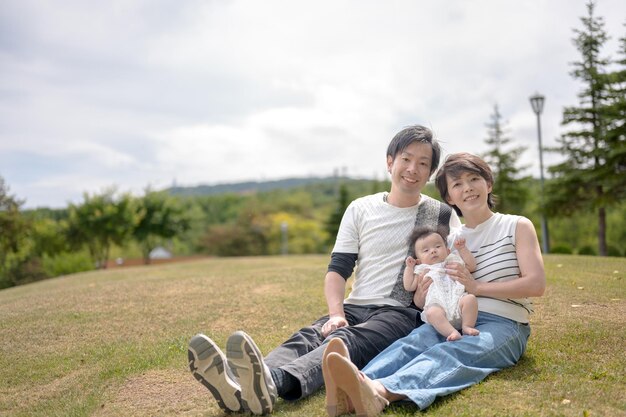 A family sits on the grass in a park