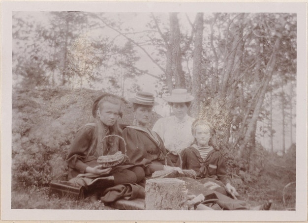 a family sits on the grass with two children