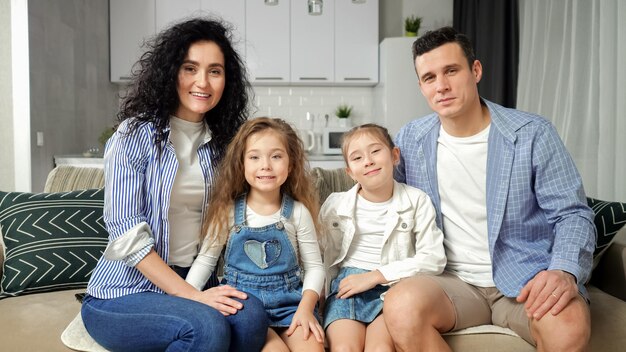 Family sits on sofa and demonstrates beautiful smiles