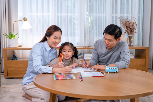 Family sitting at the floor mat in the leaving room teaching daughter drawing