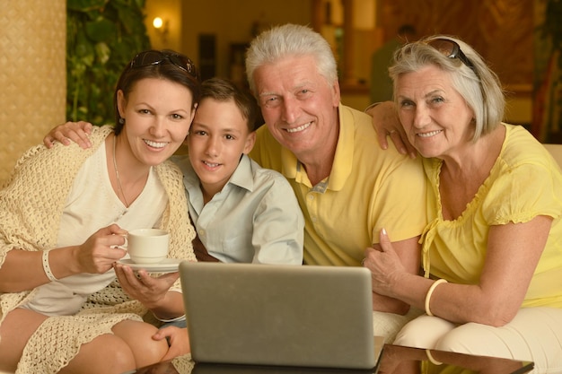 Photo family sitting near coffee table with laptop
