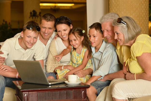 노트북이 있는 테이블 근처에 앉아 있는 가족