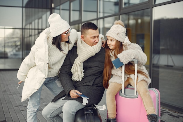 Famiglia seduta all'aperto su un bagaglio e in attesa di viaggiare