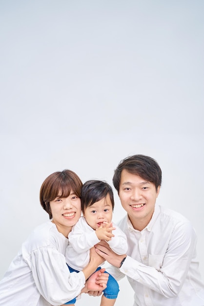 Family smiling and lining up in front of white background