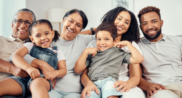 Family on sofa smile with parents children and their grandparents in home living room Group of people with kids mom and dad sit on couch with happy grandma and grandpa together