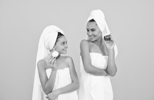 Family spa mother and teen girl hold face cream skincare relaxing together beauty treatment