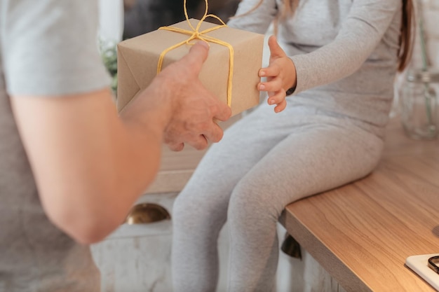 家族の特別な日思いやりのある父親からサプライズギフトを受け取っている少女のトリミングされたショット