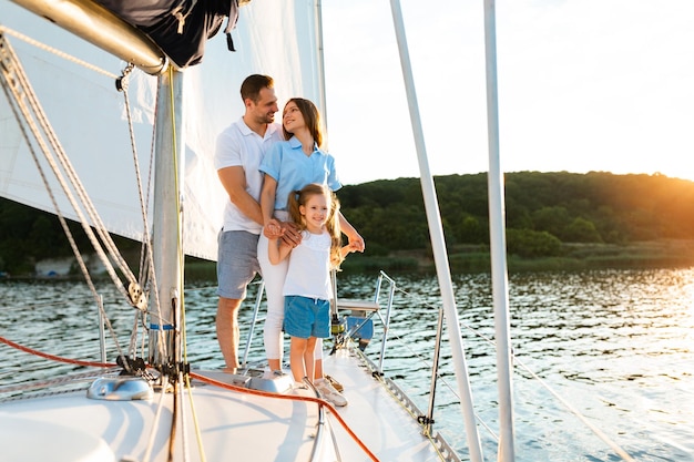 Family Spending Summer Sailing On Yacht, Posing Standing Together On Boat Deck Enjoying Sea Ride. Dream Vacation Concept. Copy Space