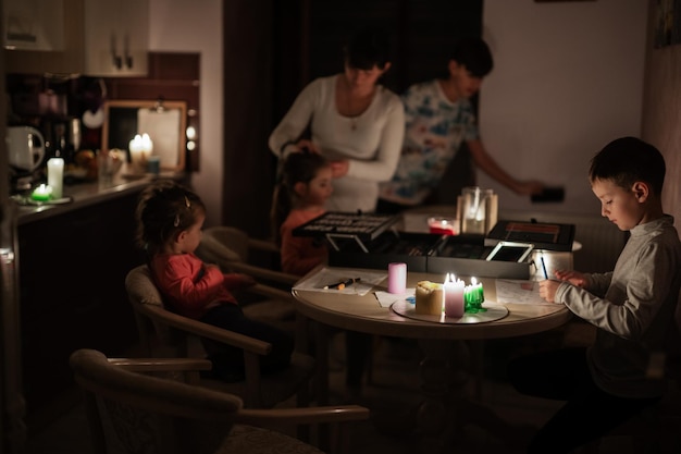 Family spending time together during an energy crisis in Europe causing blackouts Kids drawing in blackout