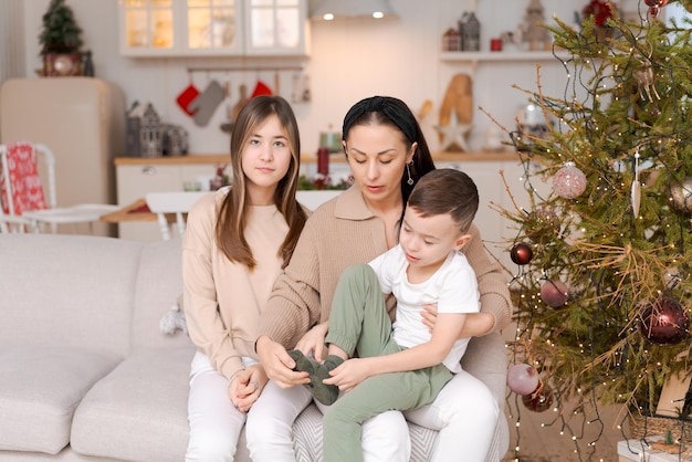 Family spends time together during christmas holidays in decorated house mother and her two children