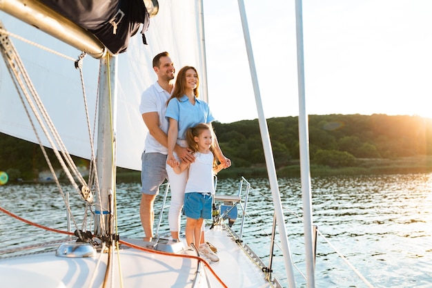 Family Standing On Yacht Deck Spending Vacation Sailing Across The Sea And Boating Near Islands Outdoor. Summer Cruise. Copy Space