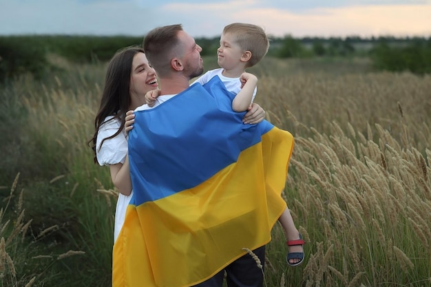 family stands with their backs with the flag of the country