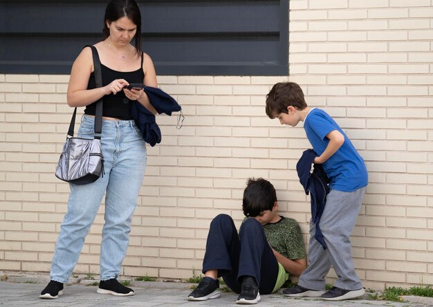 Family staying in a street addicted and obsessed with modern gadgets Kids using mobile phone