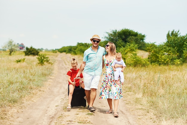 가족, 여름 휴가, 입양 및 사람들 개념-행복 한 남자, 여자와 딸 선글라스, 푸른 하늘에 재미 가방