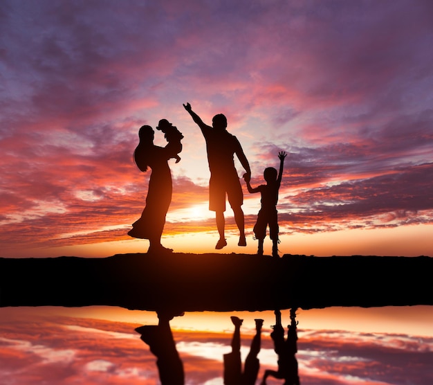 Photo family at sunset silhouettes