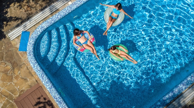 Family in swimming pool from aerial drone view 