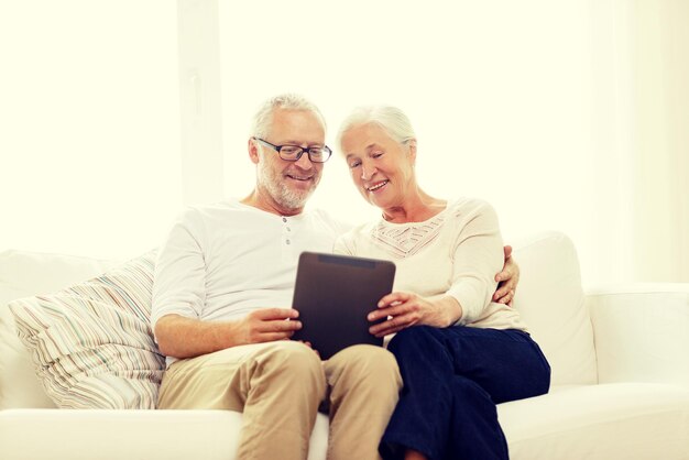 семья, технологии, возраст и концепция людей - счастливая пожилая пара с планшетным компьютером дома