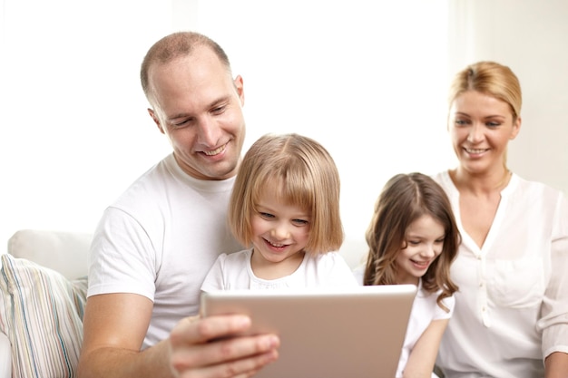 Photo family, technology and people - happy parents and children with tablet pc computers sitting on couch at home