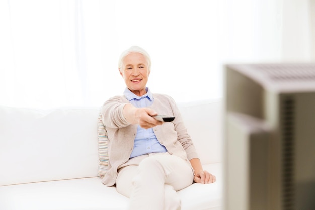 가족, 기술, 텔레비전, 나이, 사람 개념 - 집에서 TV를 시청하는 행복한 노인