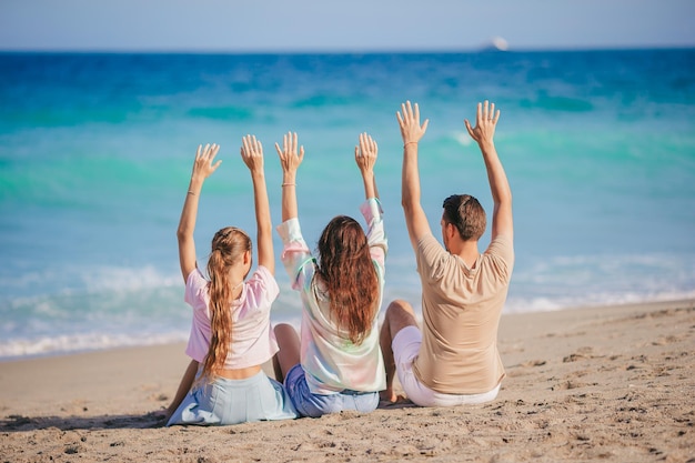 Семья из трех человек на пляже веселится вместе