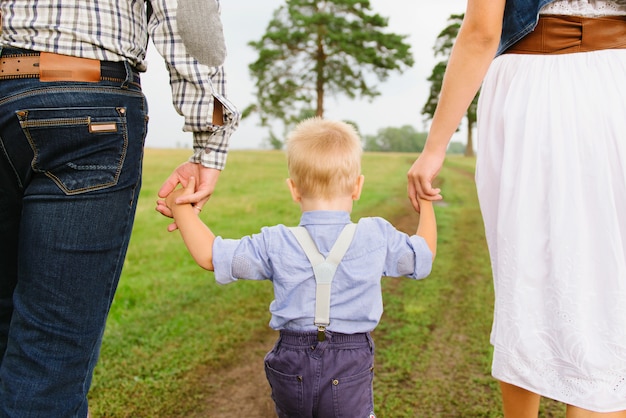 Foto famiglia di tre persone che giocano in natura