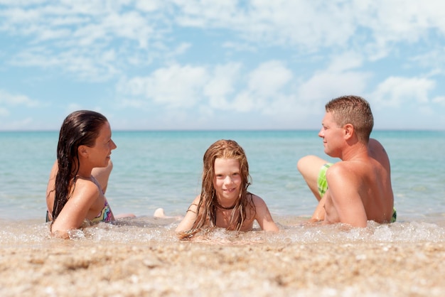 Family of three relaxing at beach