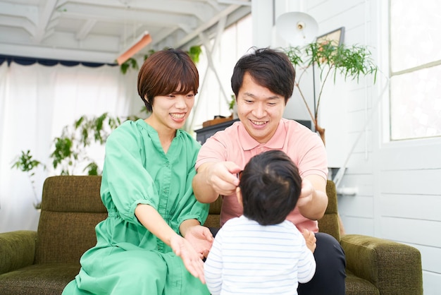 A family of three smiling and relaxing indoors