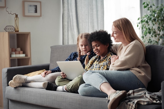 Семья из трех человек смотрит фильм на ноутбуке