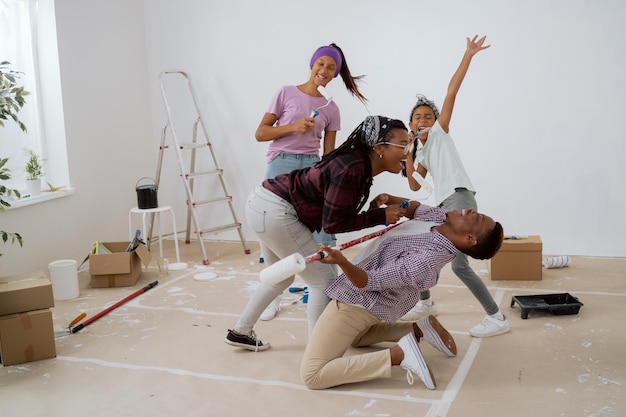 Family throws a party during apartment renovation taking a break from painting walls